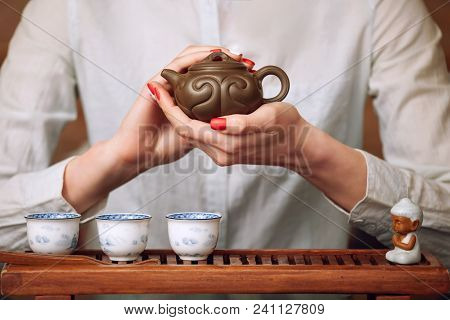 Cropped Shot Of Woman Pouring Tea In Traditional Chinese Teaware.