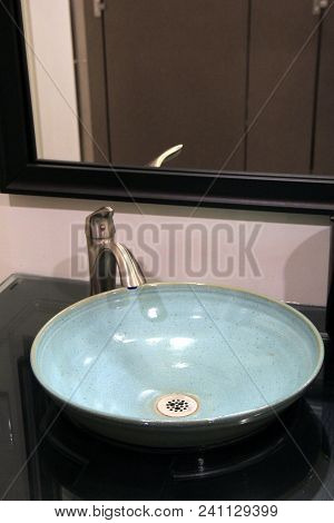 Vertical Image Of Modern Bathroom With Round Pottery Sink Made From
Red Clay And Glazed With A Robin