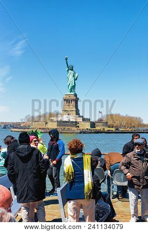 New York, Usa - April 25, 2015: Tourists On A Ferry Looking At Liberty Island And Statue In Upper Ne