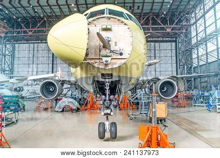 Passenger Airplane On Maintenance Of Engine And Fuselage Check Repair In Airport Hangar. With An Ope