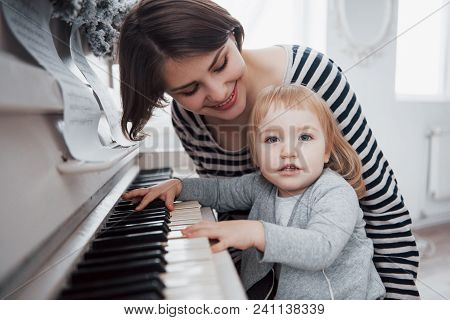 Mother And Daughter Playing White Piano, Close Up Wiew.