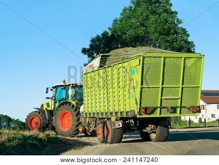 Ouhans, France - August, 25, 2016: Tractor With Trailer Full Of Hay On The Road In Bourgogne-franche