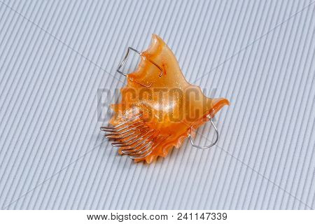 Orange Dental Braces Or Retainer For Teeth On Gray Background, Closeup