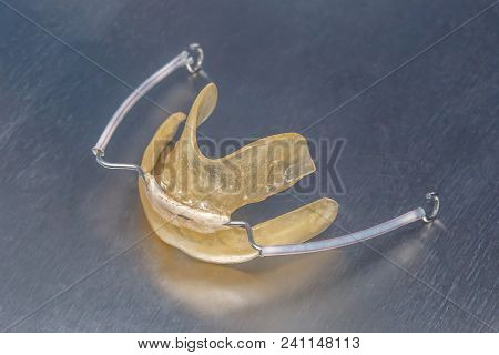 Gray Dental Braces Or Retainer For Teeth On Metall Background, Closeup