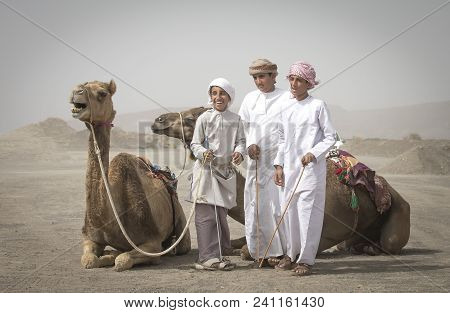 Ibri, Oman, 28th April 2018: Young Bedouin Men With Their Camels At A Countryside Of Oman