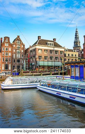 Damrak Canal, Boats And Dancing Houses In Amsterdam, Netherlands