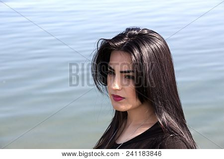 Happy Woman On The Beach. Portrait Of A Beautiful Girl Close-up. Spring Portrait On The Beach. Young