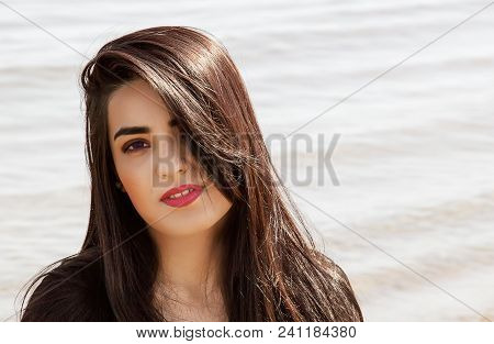 Happy Woman On The Beach. Portrait Of A Beautiful Girl Close-up. Spring Portrait On The Beach. Young