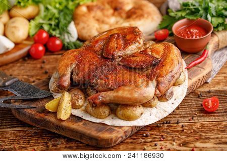 Fried Chicken With Garnish Of Baked Young Potatoes With Exquisite Appliances. Still-life On A Wooden