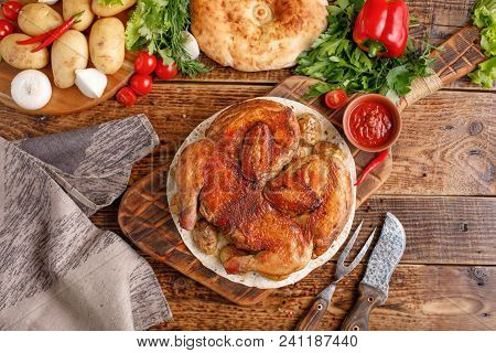 Chicken With Garnish Of Baked Young Potatoes On A Wooden Background. Still Life With Textiles And Or
