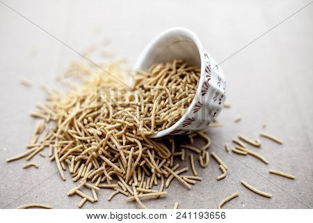 Popular Indian & Gujarati Dish Aloo Sev Or Potato Sev Or Mint Flavored Sev In A Bowl On A Brown Surf