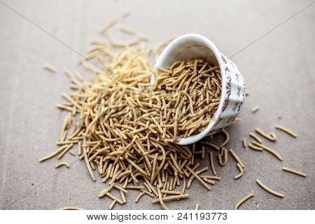 Popular Indian & Gujarati Dish Aloo Sev Or Potato Sev Or Mint Flavored Sev In A Bowl On A Brown Surf