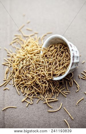 Popular Indian & Gujarati Dish Aloo Sev Or Potato Sev Or Mint Flavored Sev In A Bowl On A Brown Surf
