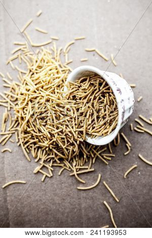 Popular Indian & Gujarati Dish Aloo Sev Or Potato Sev Or Mint Flavored Sev In A Bowl On A Brown Surf