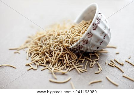 Popular Indian & Gujarati Dish Aloo Sev Or Potato Sev Or Mint Flavored Sev In A Bowl On A Brown Surf