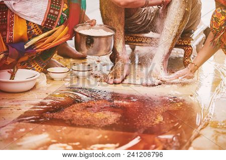 The Groom Sitting While The Family And Relatives Members Pasting Turmeric Powder (haldi) Oil Mixed W