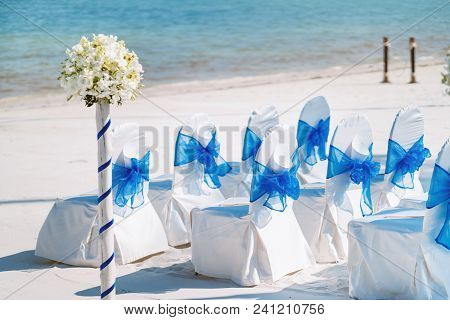 The Random White Spandex Chairs Cover With Blue Organza Sash Decoration Waiting For Beach Wedding Ve