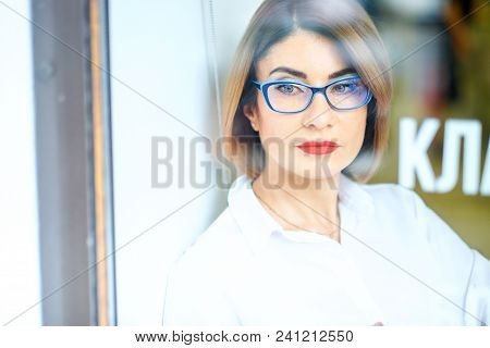 Happy Girl In White Shirt Drinking Coffee While Sitting On Windowsill In Morning
