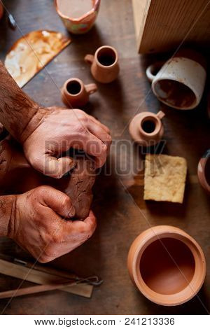 Close-up Hands Of A Male Potter In Plaid Shirt And Dirty Apron Who Molds Bowl From Clay, Selective F