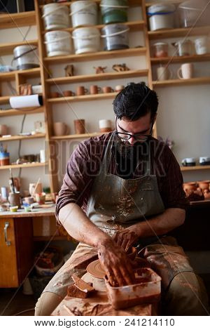 Portrait Of A Handsome Bearded Male Potter In Plaid Shirt And Dirty Apron Working In His Studio, Sel