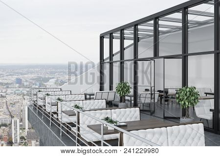 Glass Roof Restaurant With A Terrace. White Walls, A Concerete Floor And Tables With White Sofas Nea