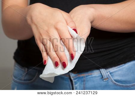 Young woman clean hands with wet wipes