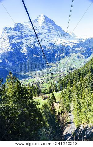 Cable Car And Tower Over Small Village On Mountain Alps, Transpotation From Grindelwald To First Pea