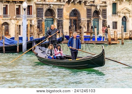 Venice, Italy - September 23, 2017: Gondoliers In Traditional Stripped Shirt Rowing A Traghetto, Che