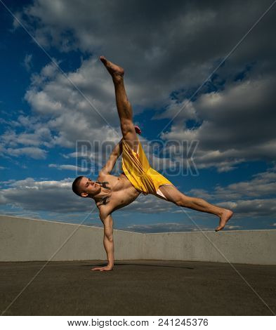 Tricking On Street. Martial Arts. Man Kick With Hand Support Barefoot. Taken From Low Angle Against 