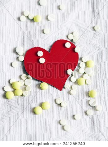 Red Heart Shape With A Pills On The White Fabric Background