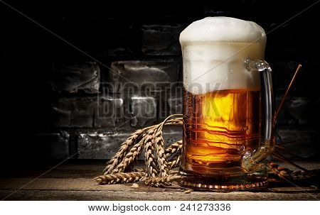 Beer In Mug And Wheet On Wooden Table And Black Background