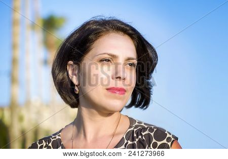 Brunette Girl On The Coast Of The Mediterranean Sea, Looks Into The Distance.