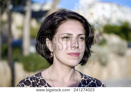 Brunette Girl On The Coast Of The Mediterranean Sea, Looks Into The Distance.