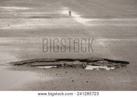 There Are Many Potholes On The Roadway Close-up