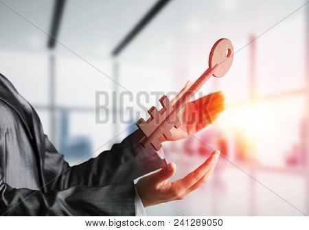 Business Woman In Black Suit Keeping Big Stone Key In Hands With Office View And Sunlight On Backgro