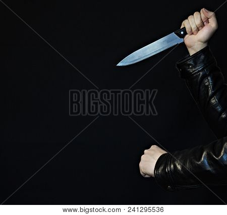 Male Hands With A Knife And Fist On A Black Background, Close-up