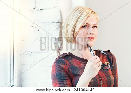 Pretty Intelligent Blonde Woman Wears Eyeglasses And Red Dress Reading Book Near Wide Window In Lagh