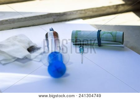 White Sheet Of Paper. It Has A Syringe With Solutions, A Needle, And Euro Money. Background Window I