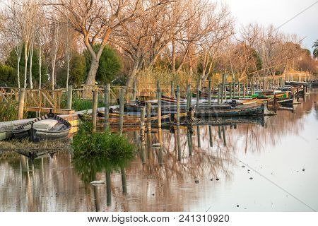Several Traditional Wooden Boats On The Mooring Dock. Harbor Of The Albufera Nature Reserve, Catarro