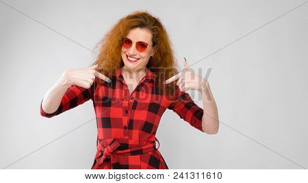 Charming Young Girl In A Checkered Cloth On A Gray Background