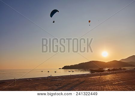 Paraglider Silhouette Flying Over Misty Mountain Valley In Beautiful Warm Sunset Colors - Sport, Act