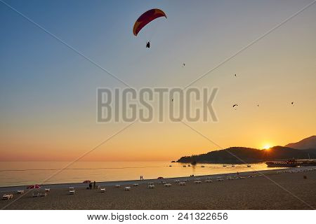 Paraglider Silhouette Flying Over Misty Mountain Valley In Beautiful Warm Sunset Colors - Sport, Act