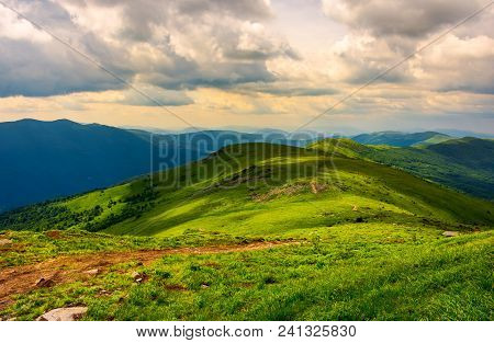 Beautiful Mountain Landscape With Grassy Hills. Sky With Fluffy Clouds. Foot Path In To The Distance