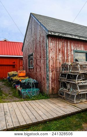 Contrasting Fishing Red Shacks With New And Old Paint And Roofs In A Village Near Rustico, Prince Ed