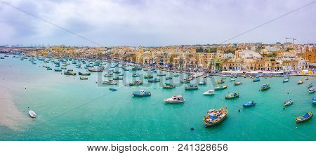 Traditional Eyed Colorful Boats Luzzu In The Harbor Of Mediterranean Fishing Village Marsaxlokk, Mal