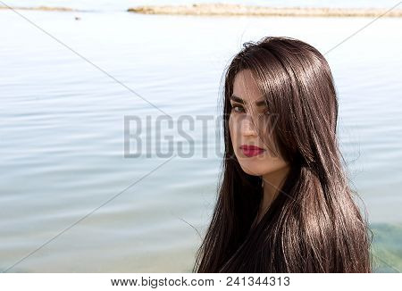 Happy Woman On The Beach. Portrait Of A Beautiful Girl Close-up. Spring Portrait On The Beach. Young
