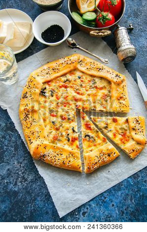 Arabic And Middle Eastern Food Concept. Cheese And Labneh Savory Galette With Olives On A Baking Pap