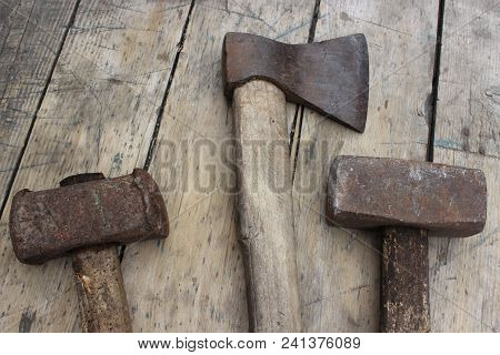 Old Hammers And An Ax Against The Background Of Wooden Boards