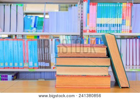 Old Book Red - Green. And Heap Treatise In School Library On Wooden Table.  Blurry Bookshelves Backg