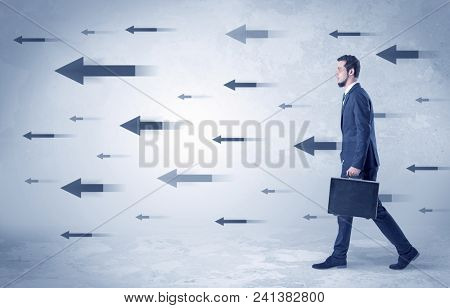 Businessman walking with arrows on the background and briefcase on his hand